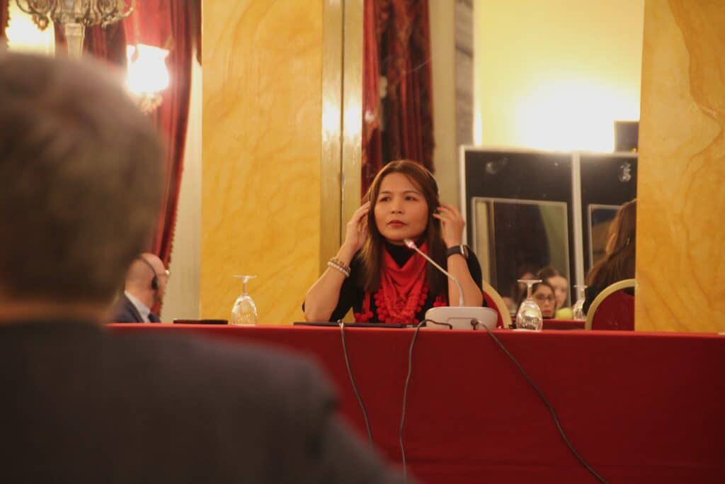 Prosecutor Mae Flores listening to translation during her spotlight session